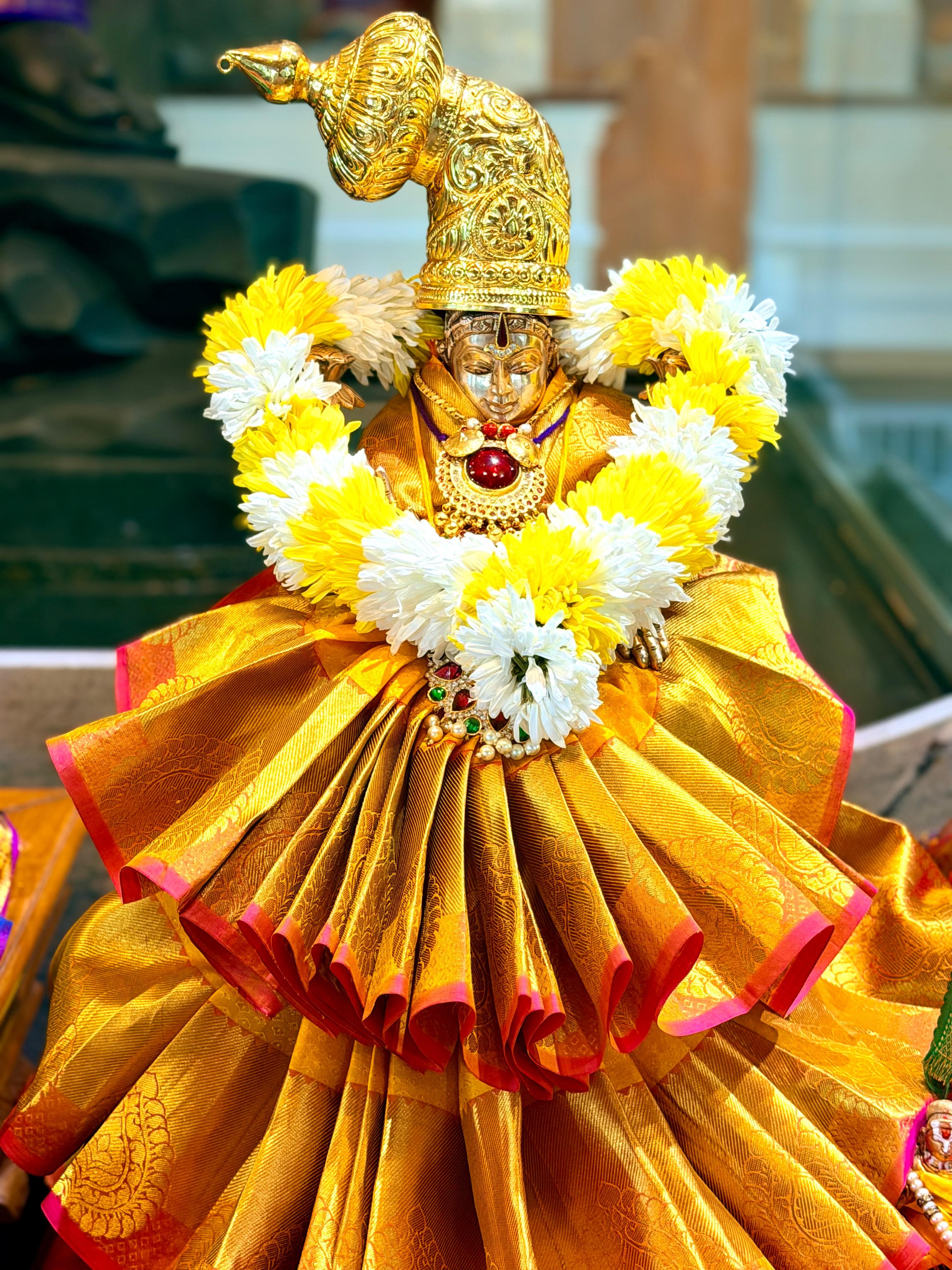 Sri: Maha: Lakshmi adorned in golden silks and garlands at Sanjeevani Jeeyar A:sramam