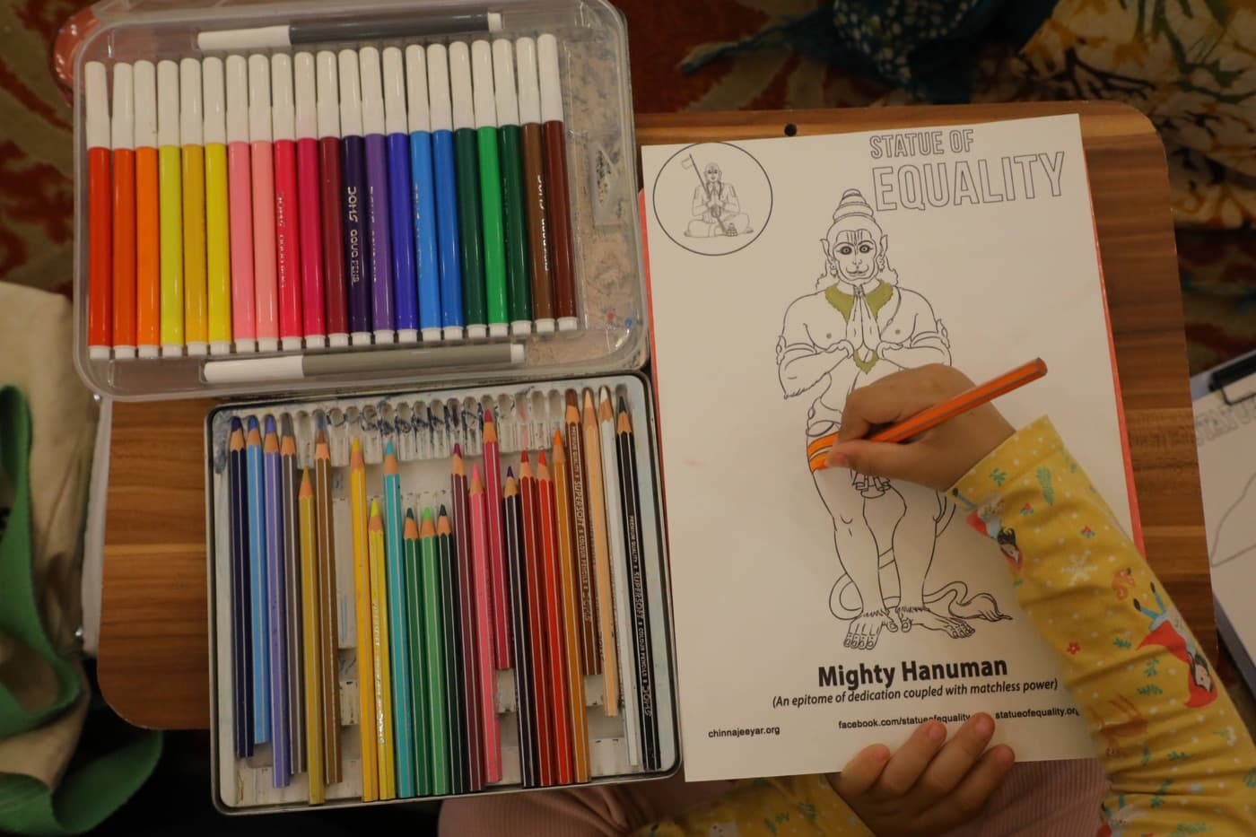 A child coloring a Statue of Equality activity sheet at a youth program